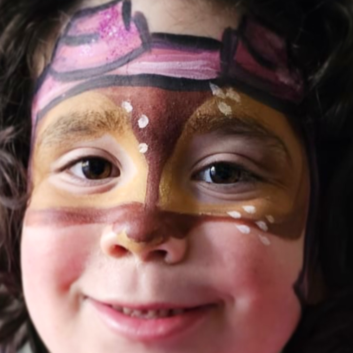 Girl with face painted like cartoon Paw Patrol character Skye.
