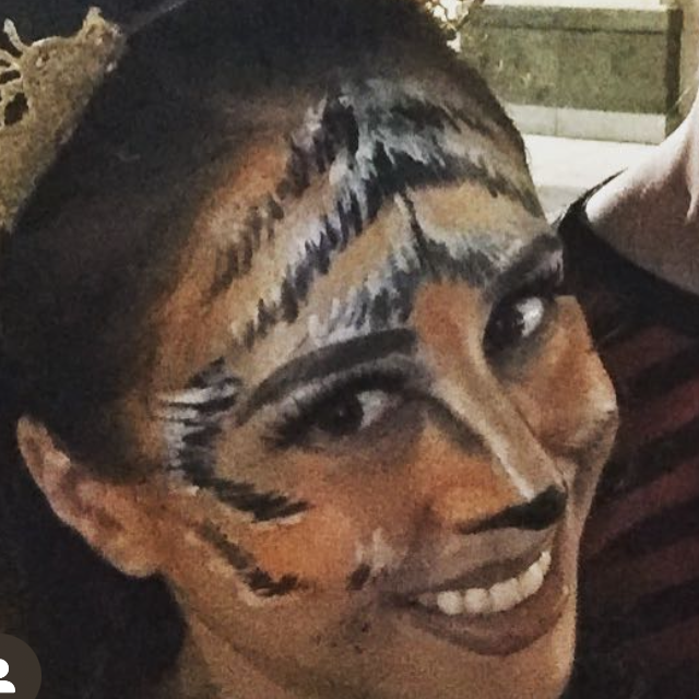 Woman with face painted like a tiger.